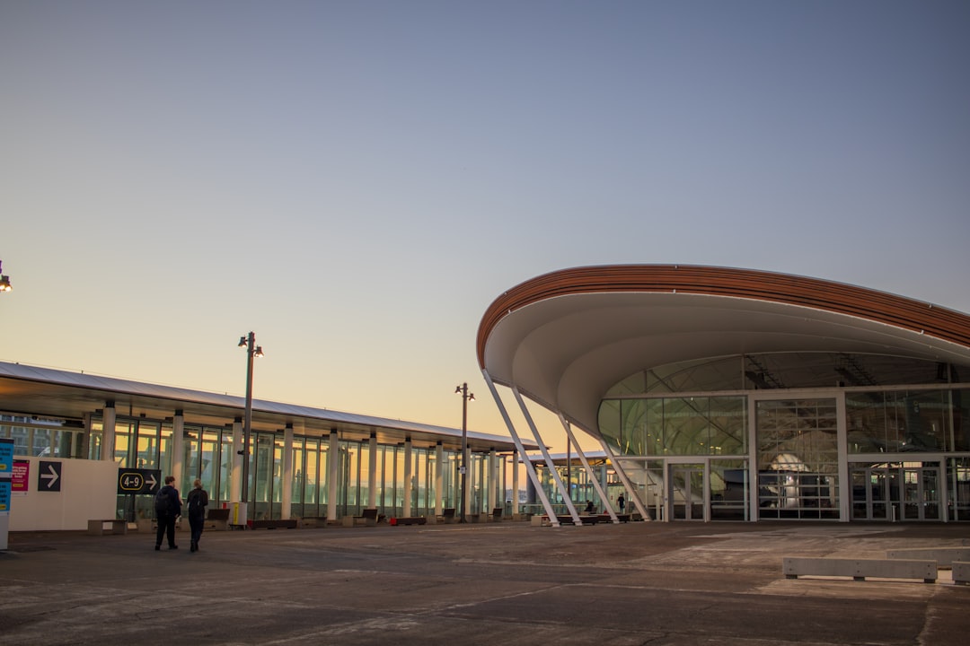 Modern buildings with curved roof and glass facade at sunset